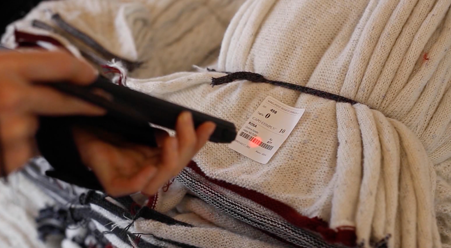 Operatore che scansiona il QR code del cartellino su un capo finito